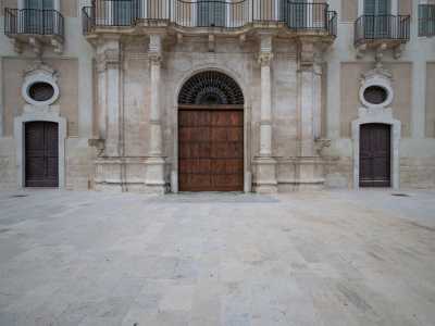 Il corpo centrale � costituito dal portale ad arco a tutto sesto che racchiude il massiccio portone in legno, il tutto inquadrato da colonne in stile ionico e da lesene binate che sostengono un balcone mistilineo in ferro